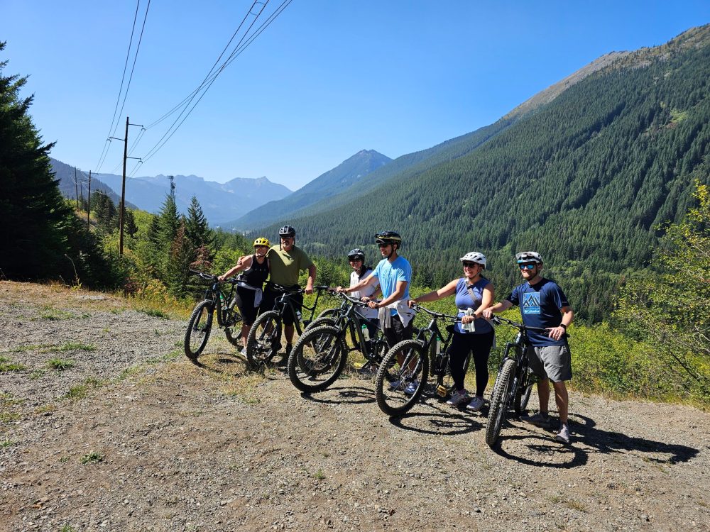 a group of people riding bikes down a dirt road