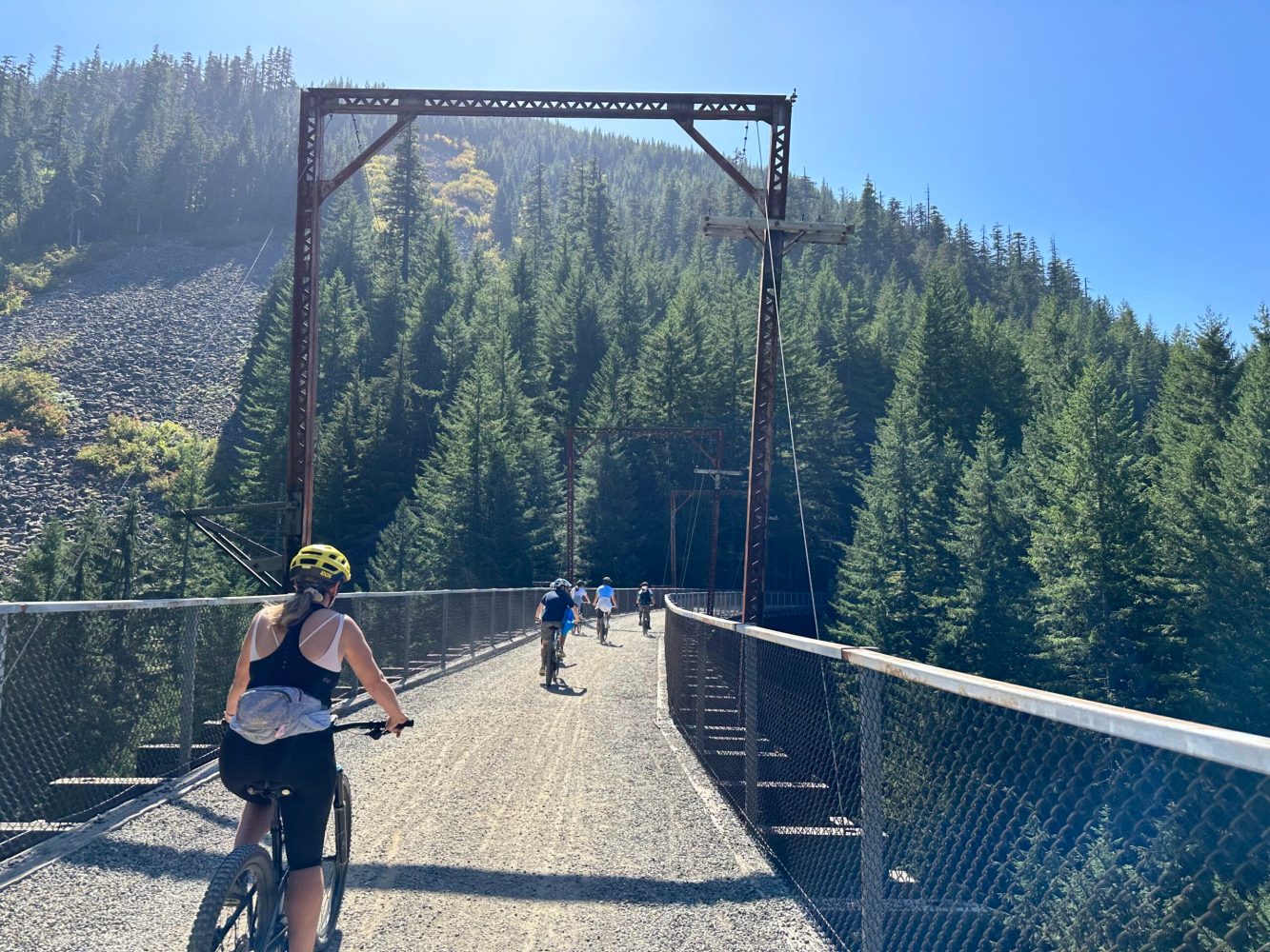 a group of people riding bikes on a bridge