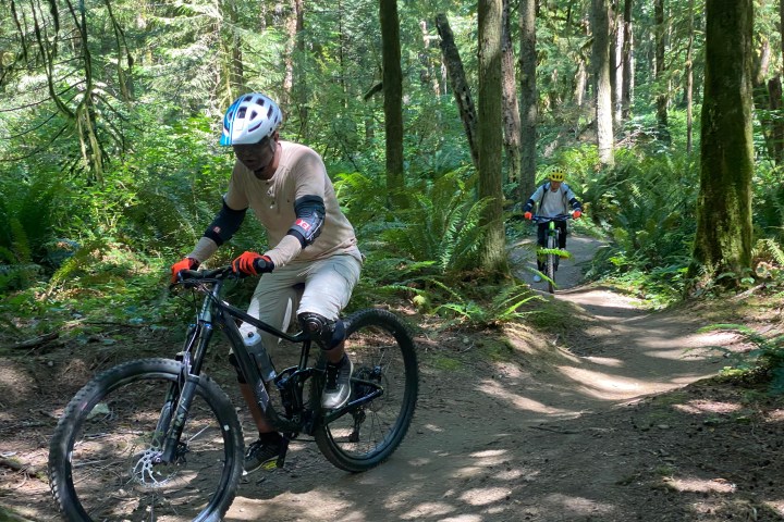 a man riding a bike down a dirt road